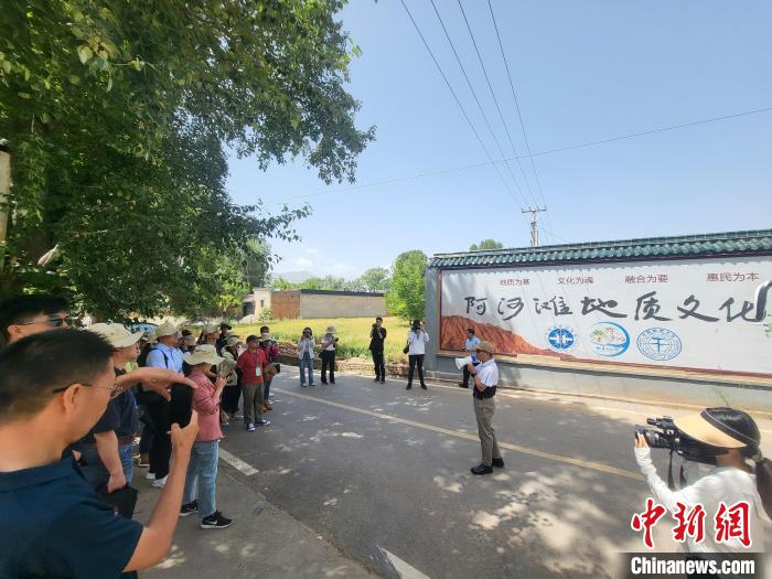 圖為中國地質(zhì)大學(xué)(北京)教授張緒教介紹村落情況。　胡友軍 攝